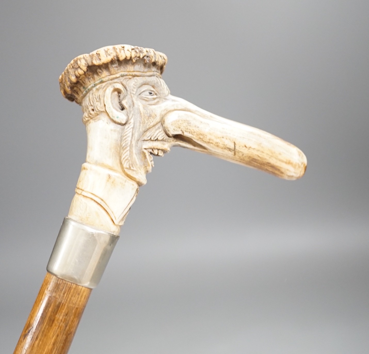 A novelty carved stag horn handled cane, of a large nosed gent, 78cms long